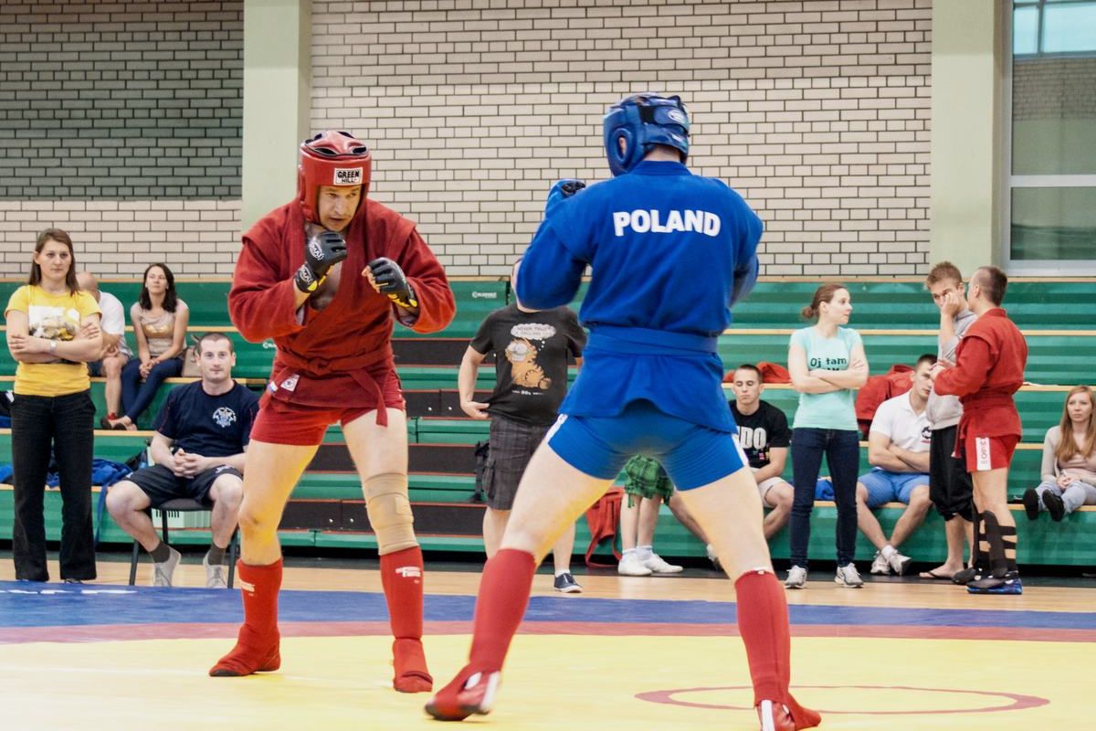 Walka w sambo bojowym, zawodnicy w kaskach i rękawicach